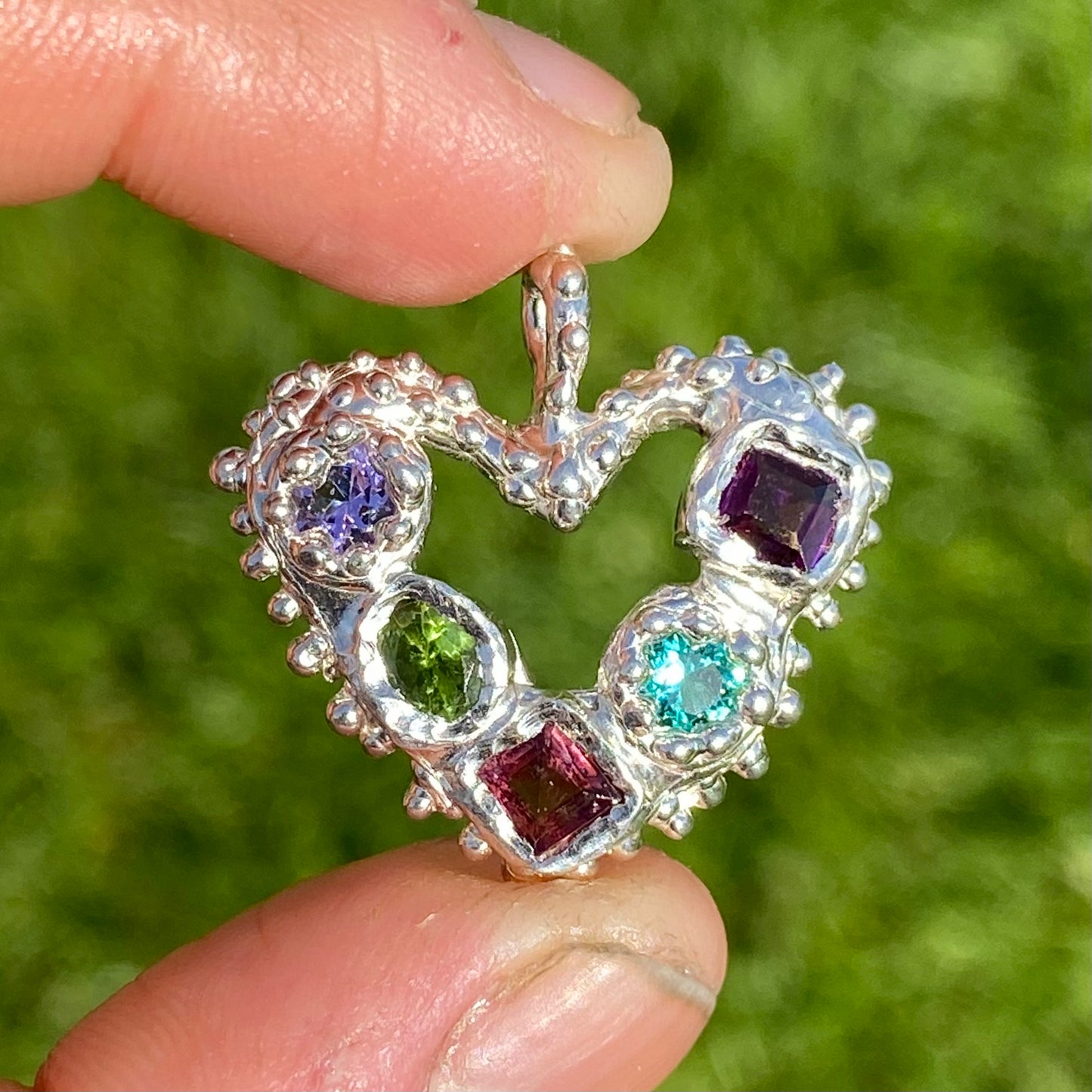 Dancing Heart Pendants are a collection of two unique, handmade pendants featuring vibrant tourmaline gemstones. Each pendant showcases five sparkling stones, playfully accented with tiny beads. Choose your favourite! They come with a delicate 42cm chain included.