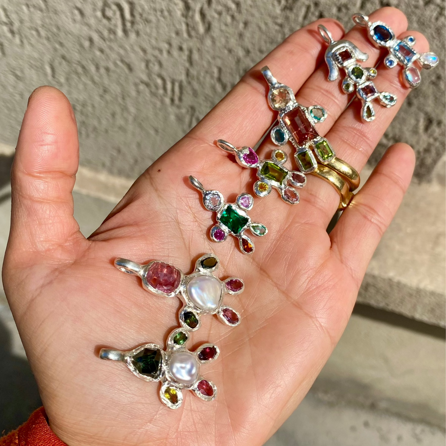 All Fairy Light Pendants together in one frame in my hand. Handmade by Lia in sterling silver in Paris.