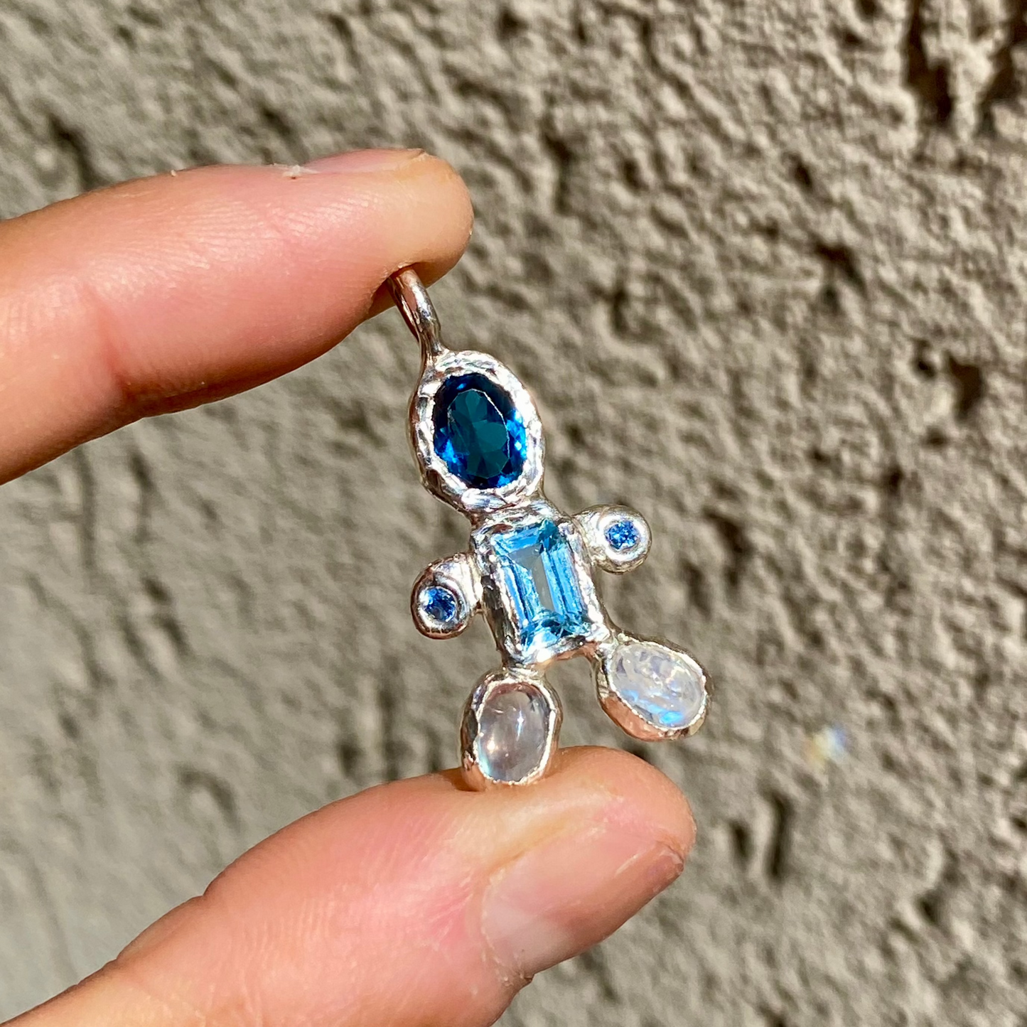 Fairy Light Pendant features light and dark blue topaz, moonstones feet. Handmade by Lia