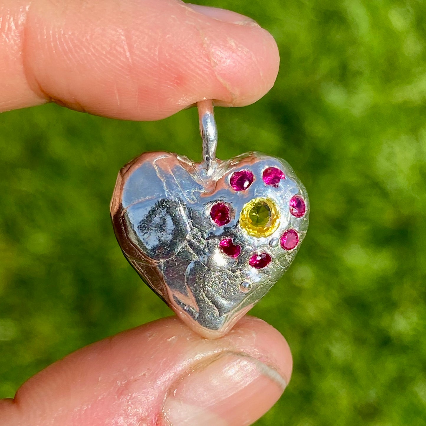 Full Bloom Heart Pendants are a collection of two handcrafted pendants, each blossoming with vibrant gemstones. Choose between a cheerful yellow and pink combination or a festive red and green pairing. Each pendant features eight sparkling stones, ready to capture your heart.