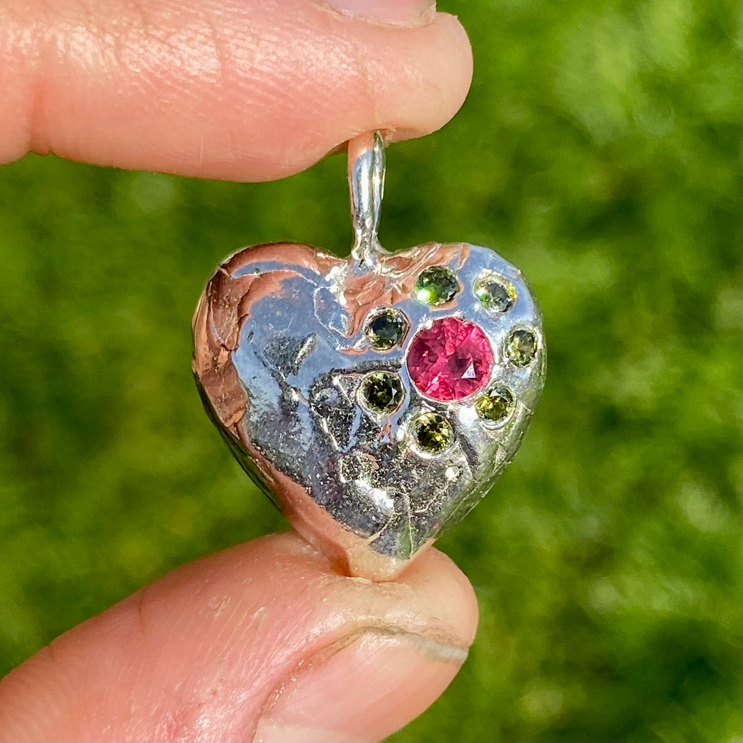 Full Bloom Heart Pendants are a collection of two handcrafted pendants, each blossoming with vibrant gemstones. Choose between a cheerful yellow and pink combination or a festive red and green pairing. Each pendant features eight sparkling stones, ready to capture your heart.