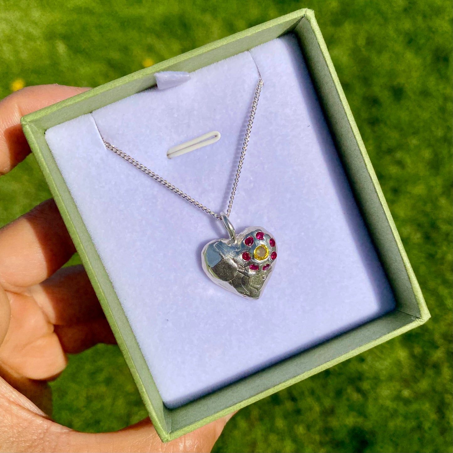 Full Bloom Heart Pendants are a collection of two handcrafted pendants, each blossoming with vibrant gemstones. Choose between a cheerful yellow and pink combination or a festive red and green pairing. Each pendant features eight sparkling stones, ready to capture your heart.
