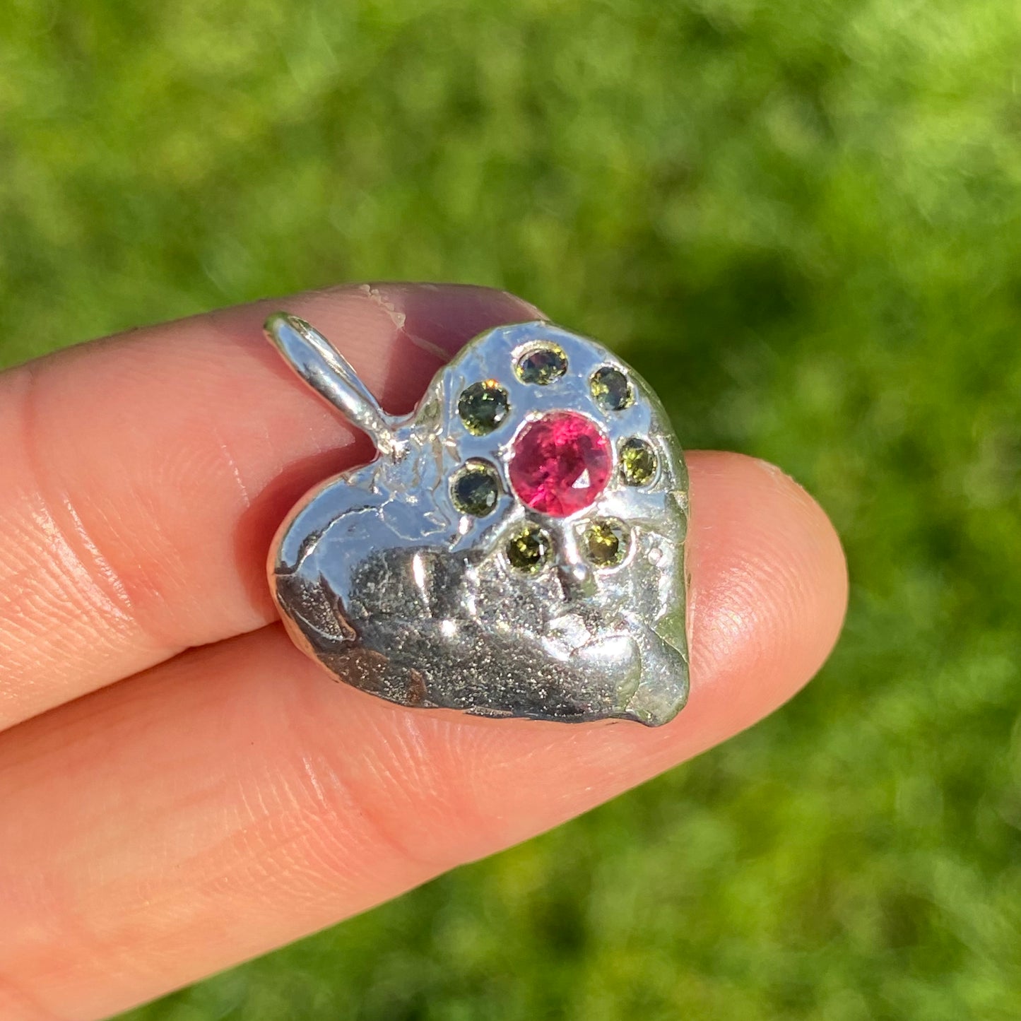 Full Bloom Heart Pendants are a collection of two handcrafted pendants, each blossoming with vibrant gemstones. Choose between a cheerful yellow and pink combination or a festive red and green pairing. Each pendant features eight sparkling stones, ready to capture your heart.