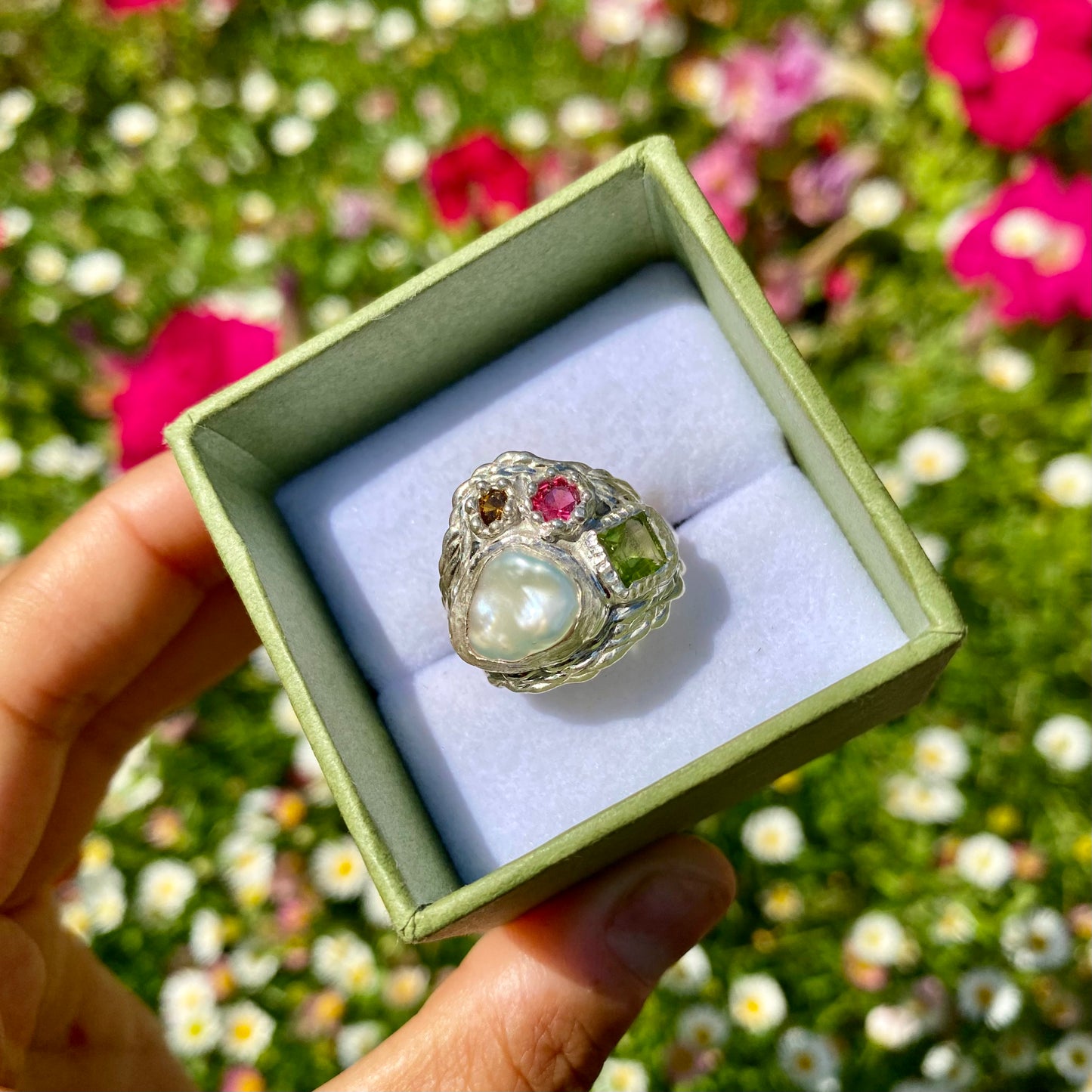 The Harmony features a thick band with four stones: a keshi pearl, a green peridot, pink and orange. Handmade by me, this ring is available in size N (US 6 1/2).