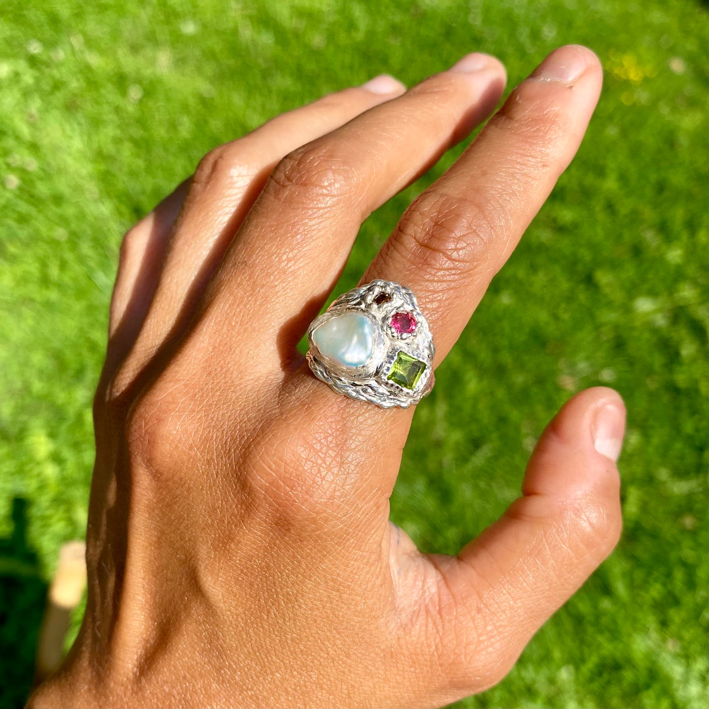 The Harmony features a thick band with four stones: a keshi pearl, a green peridot, pink and orange. Handmade by me, this ring is available in size N (US 6 1/2).