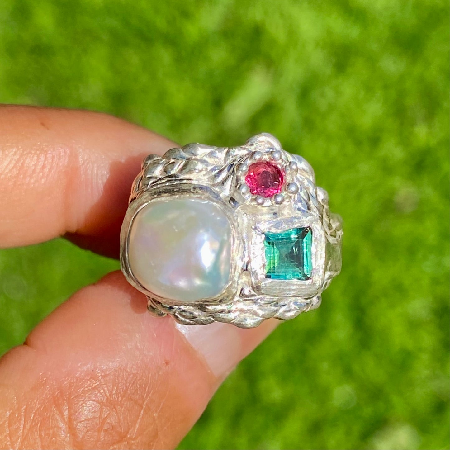 The Pearl Grove features a thick band with three stones: Keshi pearl, green square tourmaline, and pink round stone. Handmade by me from sterling silver, this ring is available in size O (US 7)