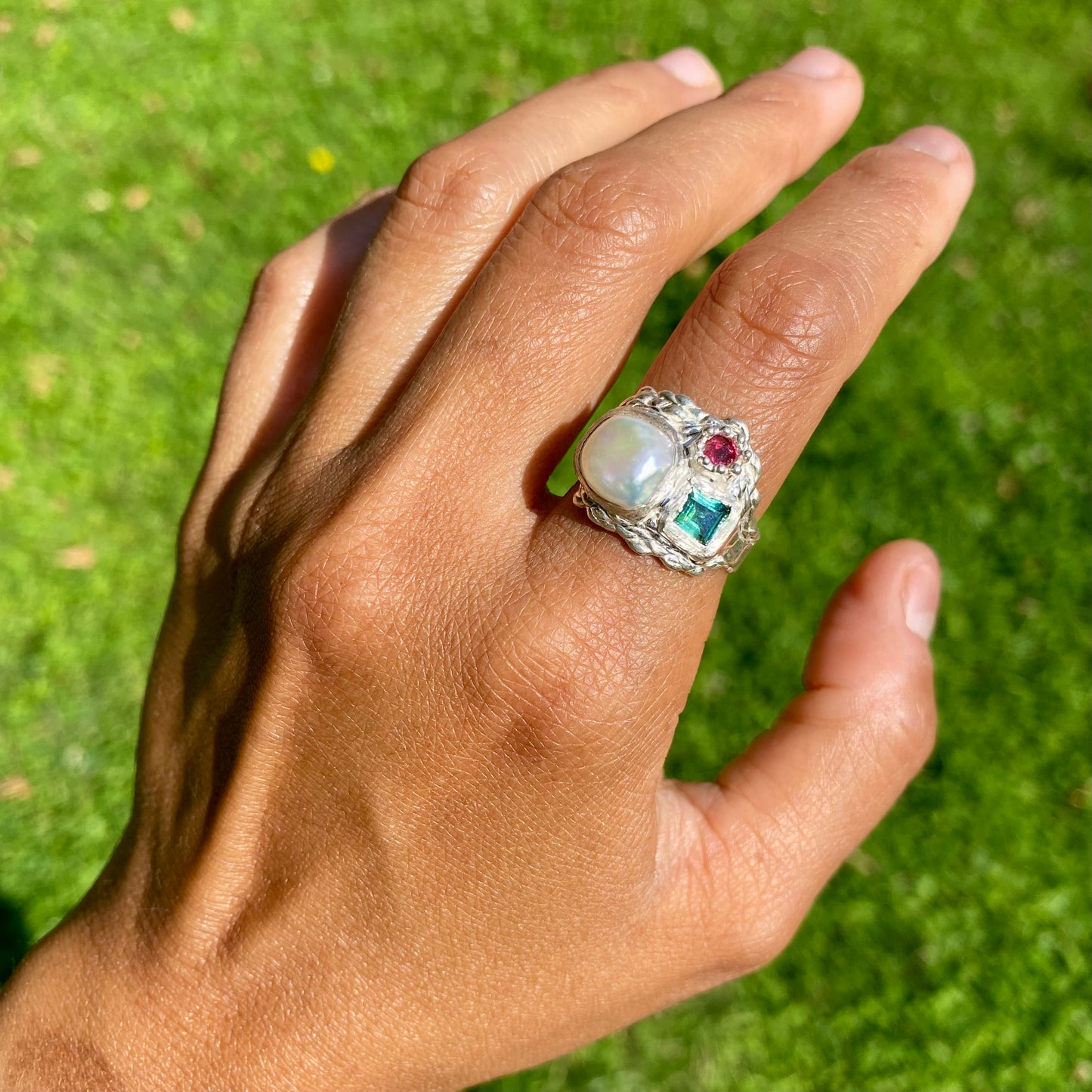 The Pearl Grove features a thick band with three stones: Keshi pearl, green square tourmaline, and pink round stone. Handmade by me from sterling silver, this ring is available in size O (US 7)