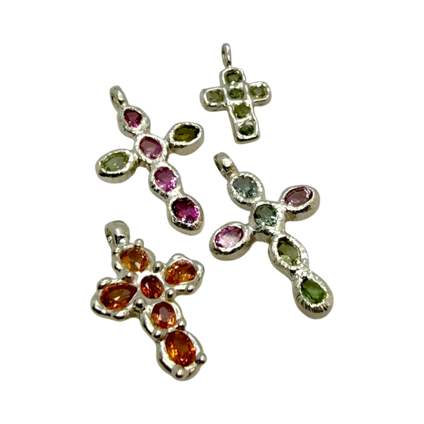 Group of handmade Harmony Cross pendants in sterling silver with pink and green tourmalines, crafted by Lia Makes Jewellery in Paris.