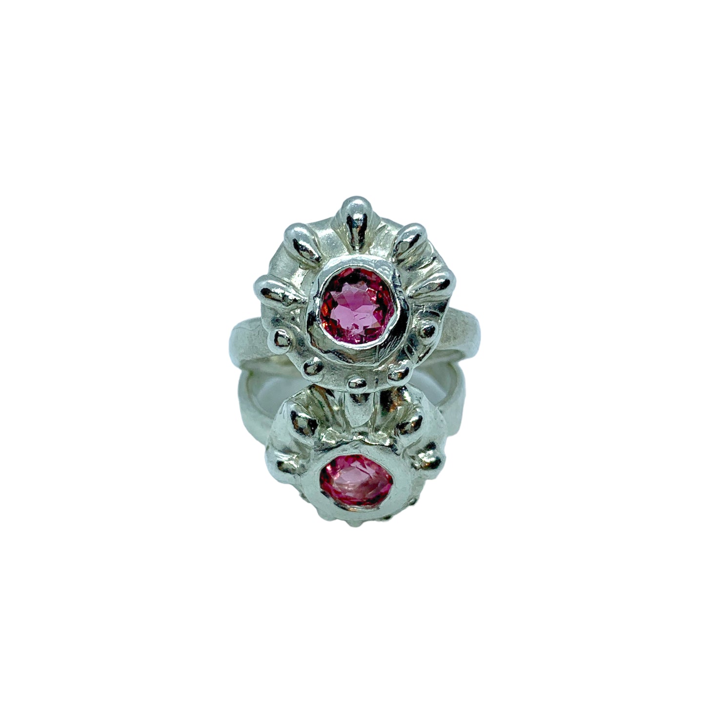 Introducing the Raffles Ring, a fun and casual silver ring that features a pretty pink tourmaline stone in the middle and a bumpy pattern around the stones that gives it a unique and playful look. It's perfect for everyday wear.