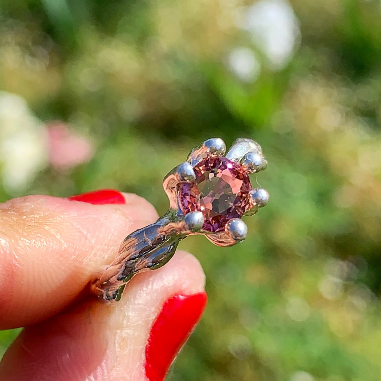 The Rosette ring coms with pink spinel stone. Made with sterling silver and held securely in place by six claws, this ring comes in a size K 1/2 or 5 3/8.