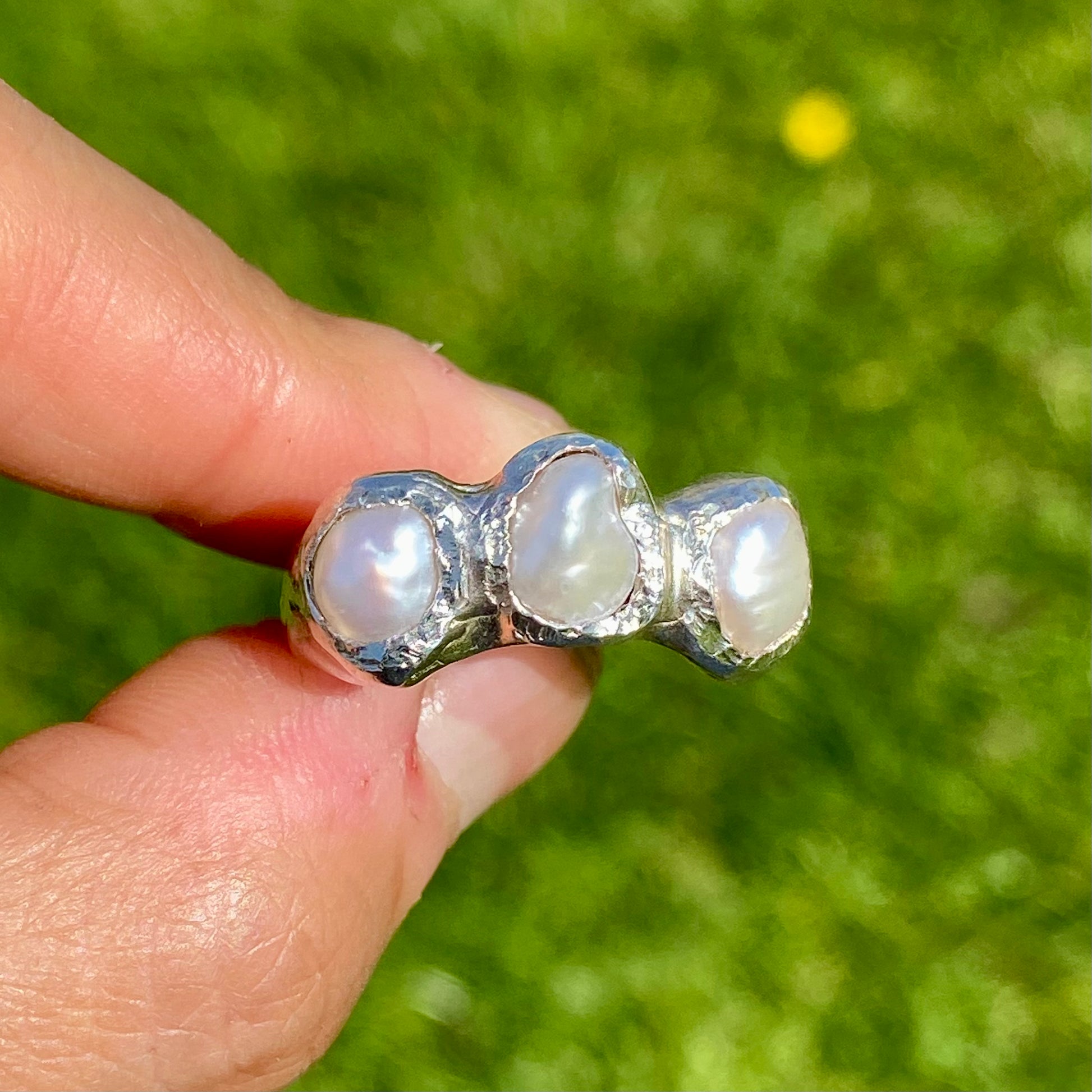 Double Harmony Rings come in a set of two. One ring features a pink tourmaline stone, and the other features three small pearl stones. Handmade from sterling silver, these stacking rings come in a single size: O ½ (or 7 ¼).