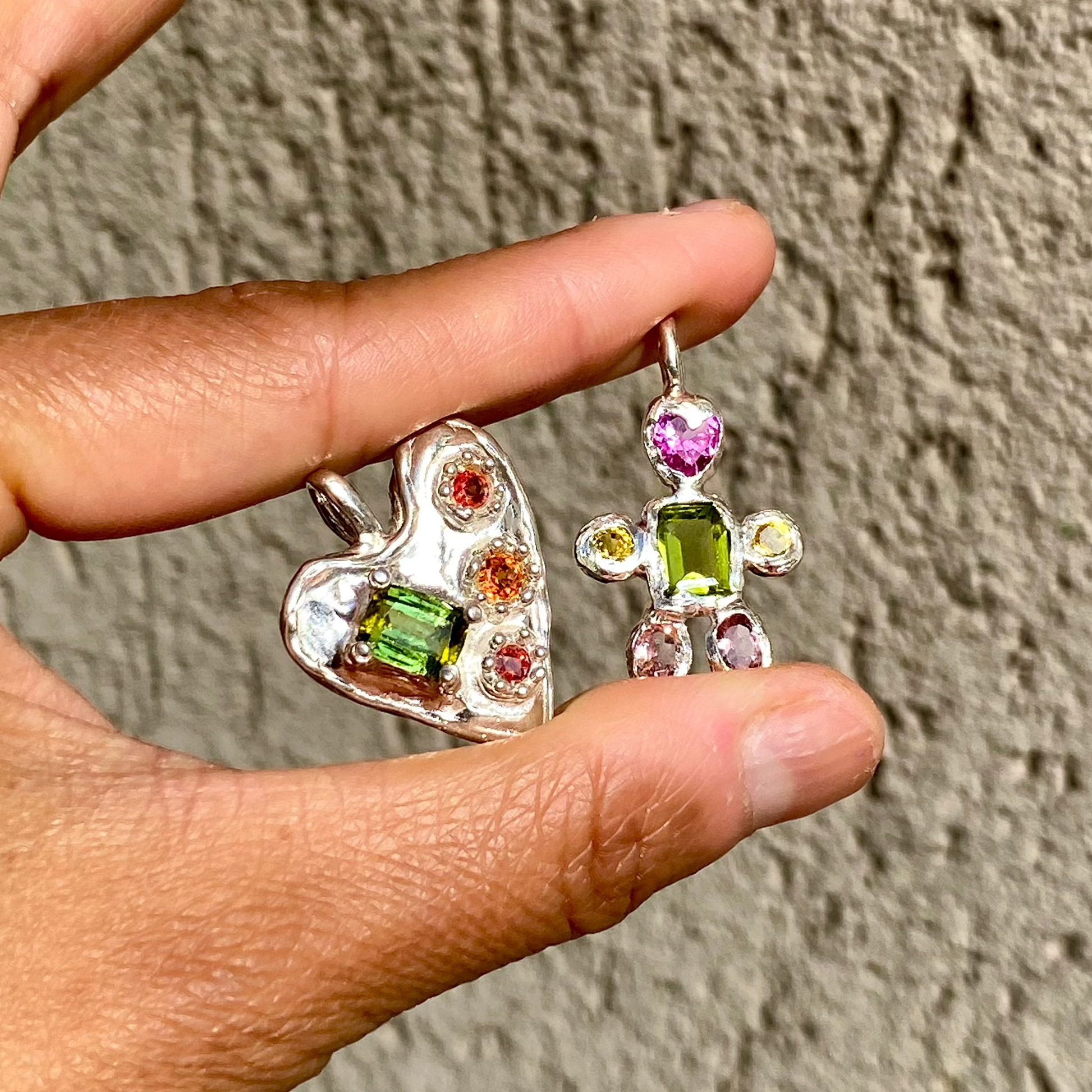  Handmade by Lia from Lia Makes Jewellery, this sterling silver heart-shaped pendant features a unique combination of colourful stones like tourmalines, sapphires, citrine, pink and blue topaz, and tiny synthetic gems, shown in a close-up to highlight the vibrant setting.
