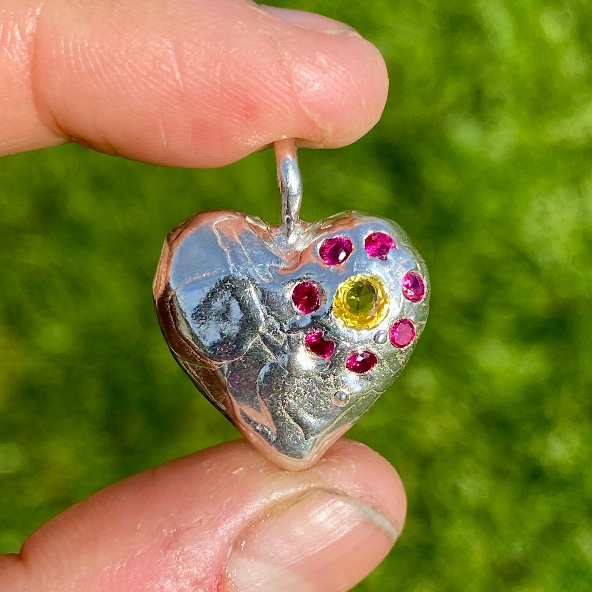 Full Bloom Heart Pendants are a collection of two handcrafted pendants, each blossoming with vibrant gemstones. Choose between a cheerful yellow and pink combination or a festive red and green pairing. Each pendant features eight sparkling stones, ready to capture your heart. 