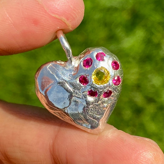 Full Bloom Heart Pendants are a collection of two handcrafted pendants, each blossoming with vibrant gemstones. Choose between a cheerful yellow and pink combination or a festive red and green pairing. Each pendant features eight sparkling stones, ready to capture your heart. 