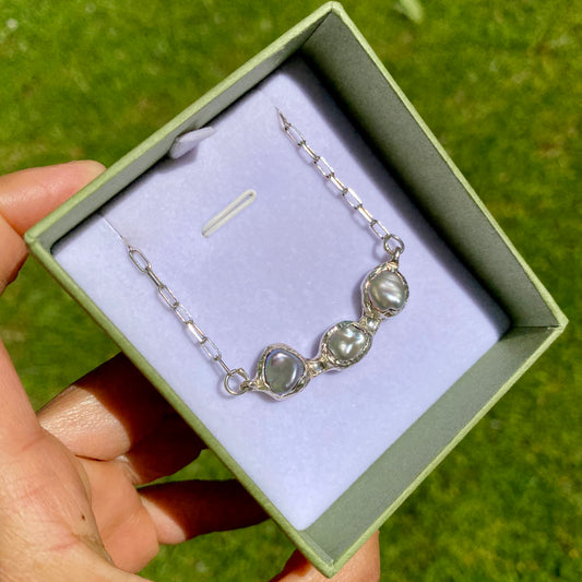This Grey Pearl Pendant is crafted from sterling silver and features three beautiful grey pearls. Perfect for everyday wear. Suspended from a delicate chain, the necklace is adjustable with a 5cm extension chain, offering a total length of 46cm.