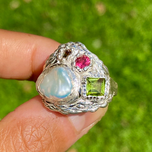 The Harmony features a thick band with four stones: a keshi pearl, a green peridot, pink and orange. Handmade by me, this ring is available in size N (US 6 1/2).
