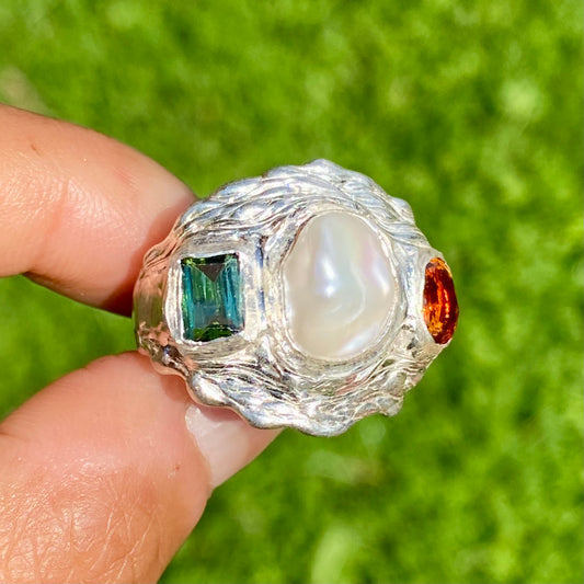The Ocean Flame features a thick band with three stones: Keshi pearl, green rectangle tourmaline, and orange citrine stone. Handmade by me from sterling silver, this ring is available in size O 1/2 (US 7 1/4).