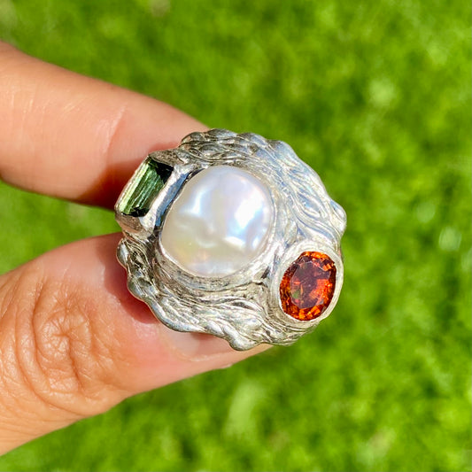 The Ocean Flame features a thick band with three stones: Keshi pearl, green rectangle tourmaline, and orange citrine stone. Handmade by me from sterling silver, this ring is available in size O 1/2 (US 7 1/4).