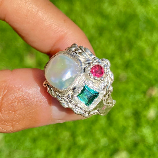 The Pearl Grove features a thick band with three stones: Keshi pearl, green square tourmaline, and pink round stone. Handmade by me from sterling silver, this ring is available in size O (US 7)
