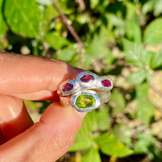 Pink Oasis Ring Stack comes as a set of two stacking rings. One ring features three pink tourmaline stones, while the other holds a green peridot. Handmade by me in sterling silver, these rings are available in size P (US 7 1/2).