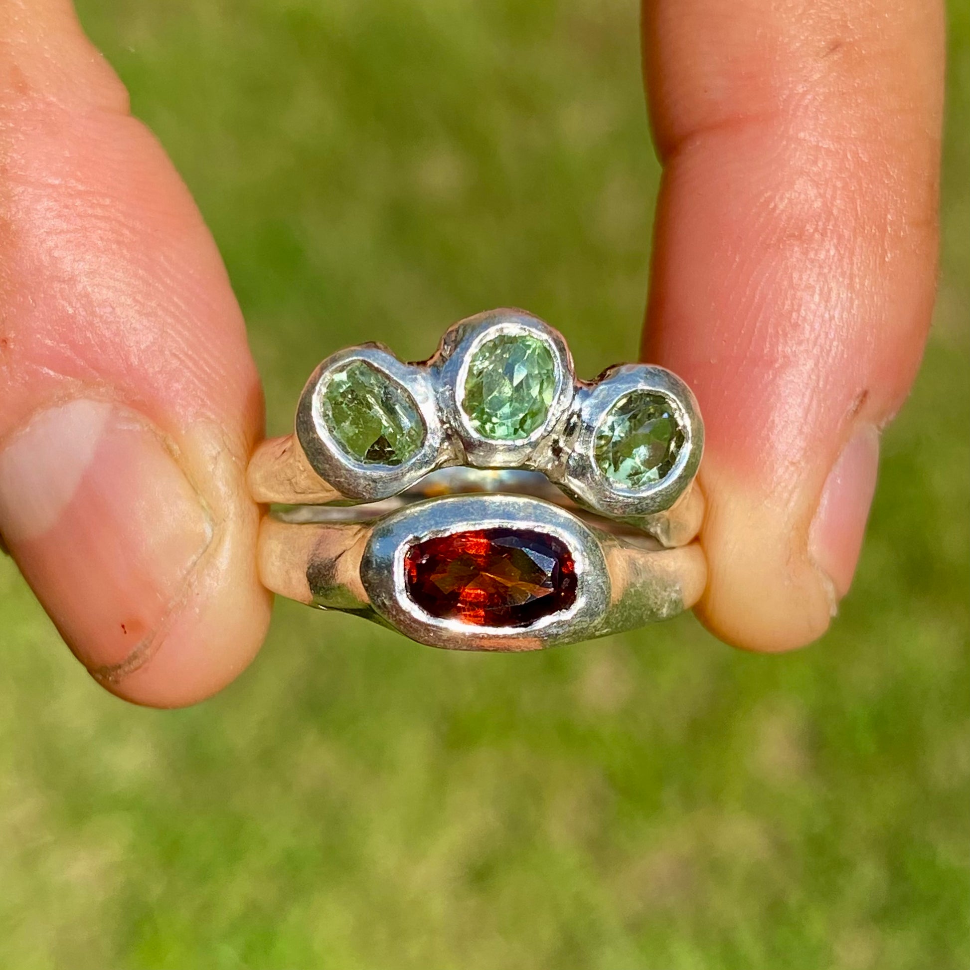 The Red Forest ring stack comes as a set of two. One ring features three light green bluish tourmaline stones, and the other has a long red oval garnet stone. Handmade by me from sterling silver, these stacking rings are available in one size:&nbsp;O ½ (US 7 ¼)