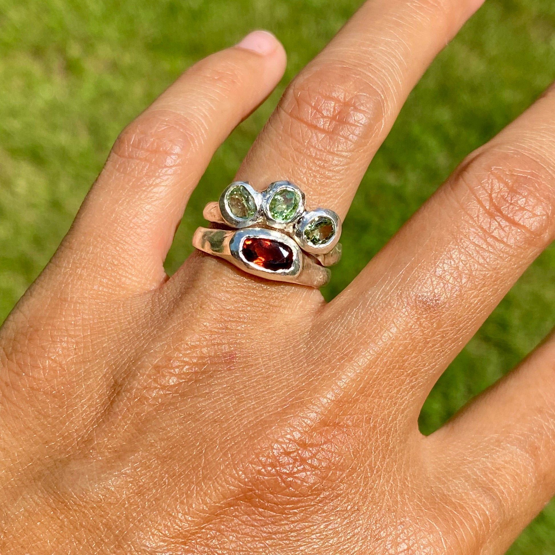 The Red Forest ring stack comes as a set of two. One ring features three light green bluish tourmaline stones, and the other has a long red oval garnet stone. Handmade by me from sterling silver, these stacking rings are available in one size:&nbsp;O ½ (US 7 ¼)