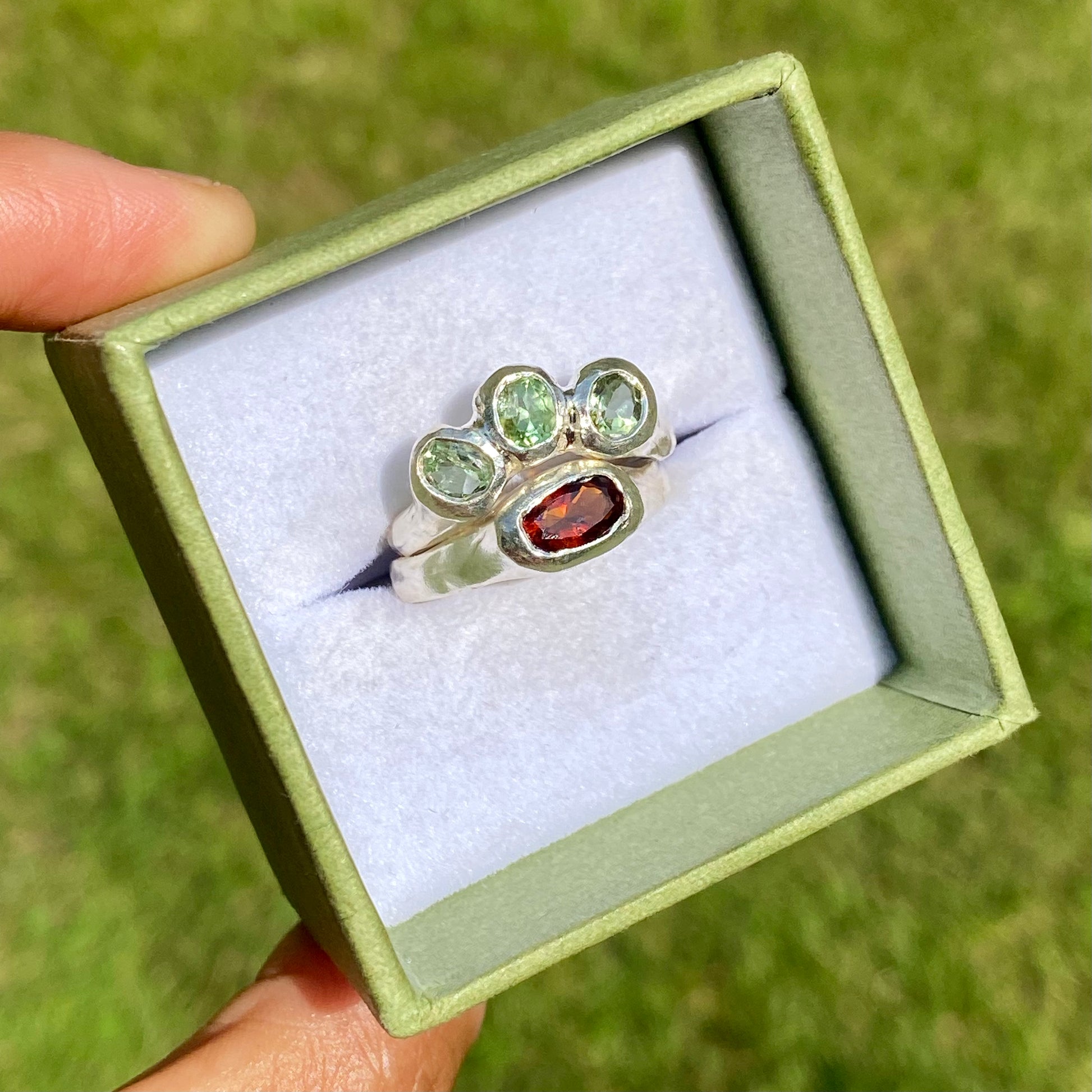 The Red Forest ring stack comes as a set of two. One ring features three light green bluish tourmaline stones, and the other has a long red oval garnet stone. Handmade by me from sterling silver, these stacking rings are available in one size:&nbsp;O ½ (US 7 ¼)