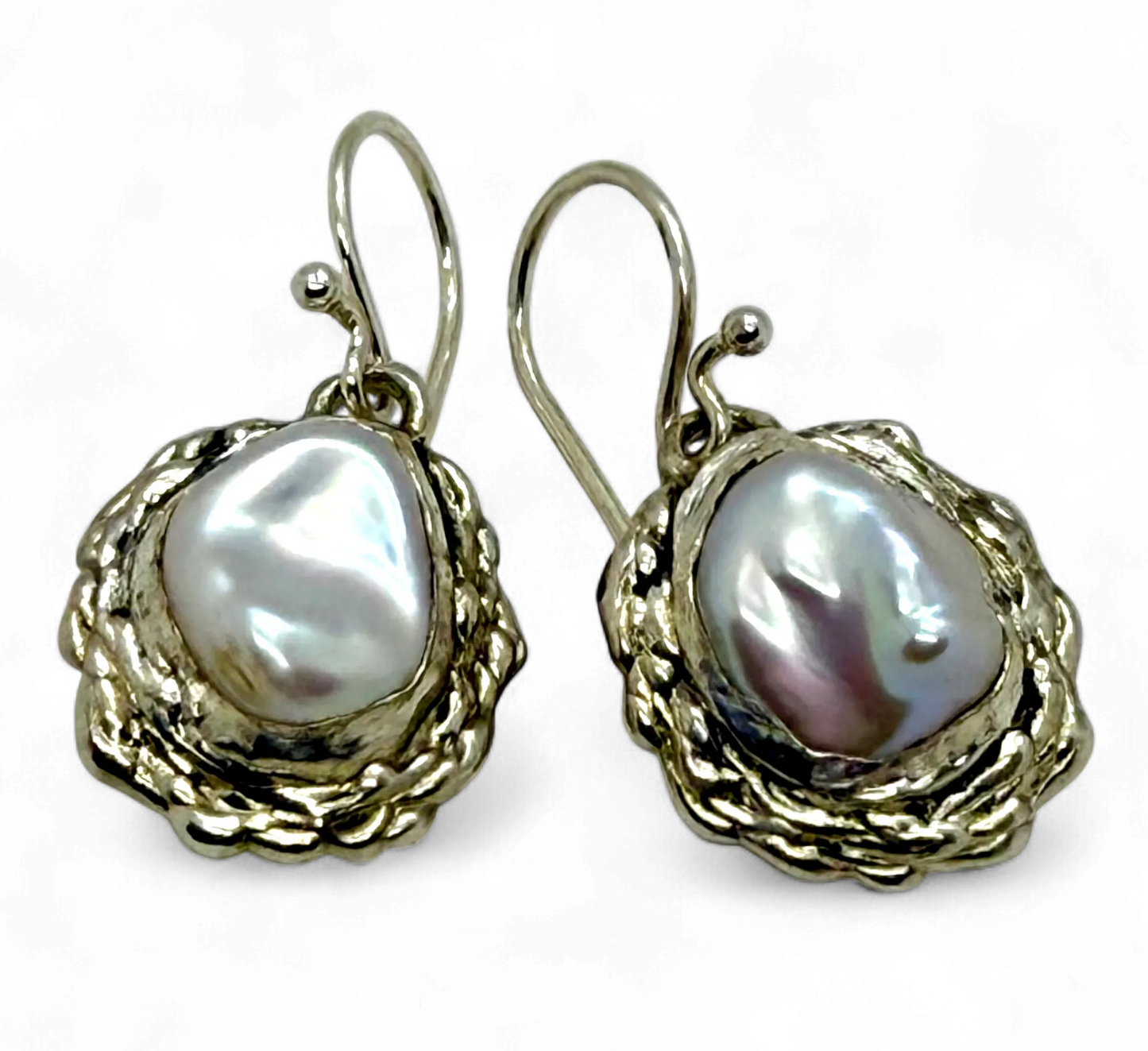 Close-up of Bulan Dangles earrings showing sterling silver texture and luminous white pearls.