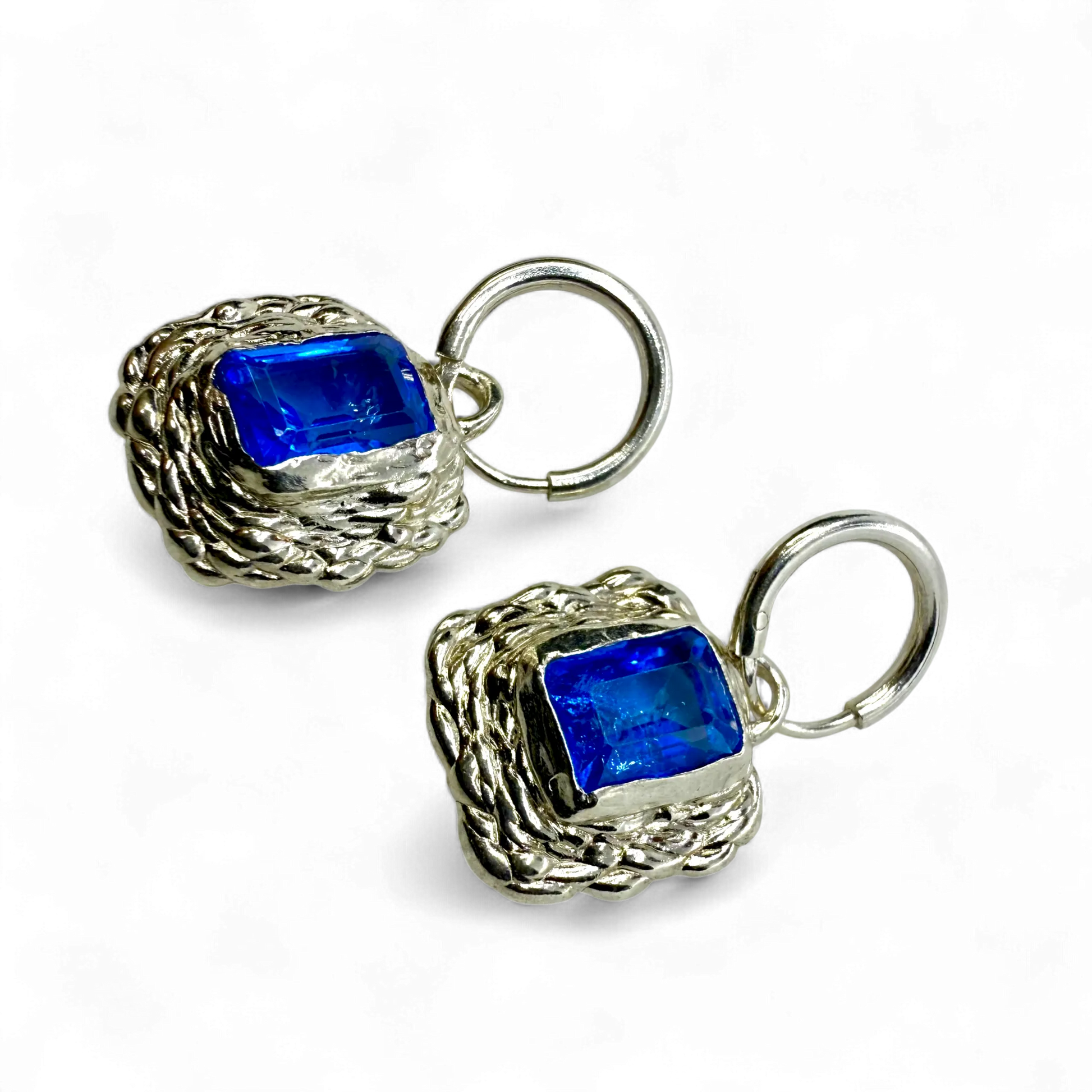 Front view of Astra Hoops showing sterling silver hoops with sparkling blue topaz stones.