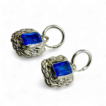 Front view of Astra Hoops showing sterling silver hoops with sparkling blue topaz stones.