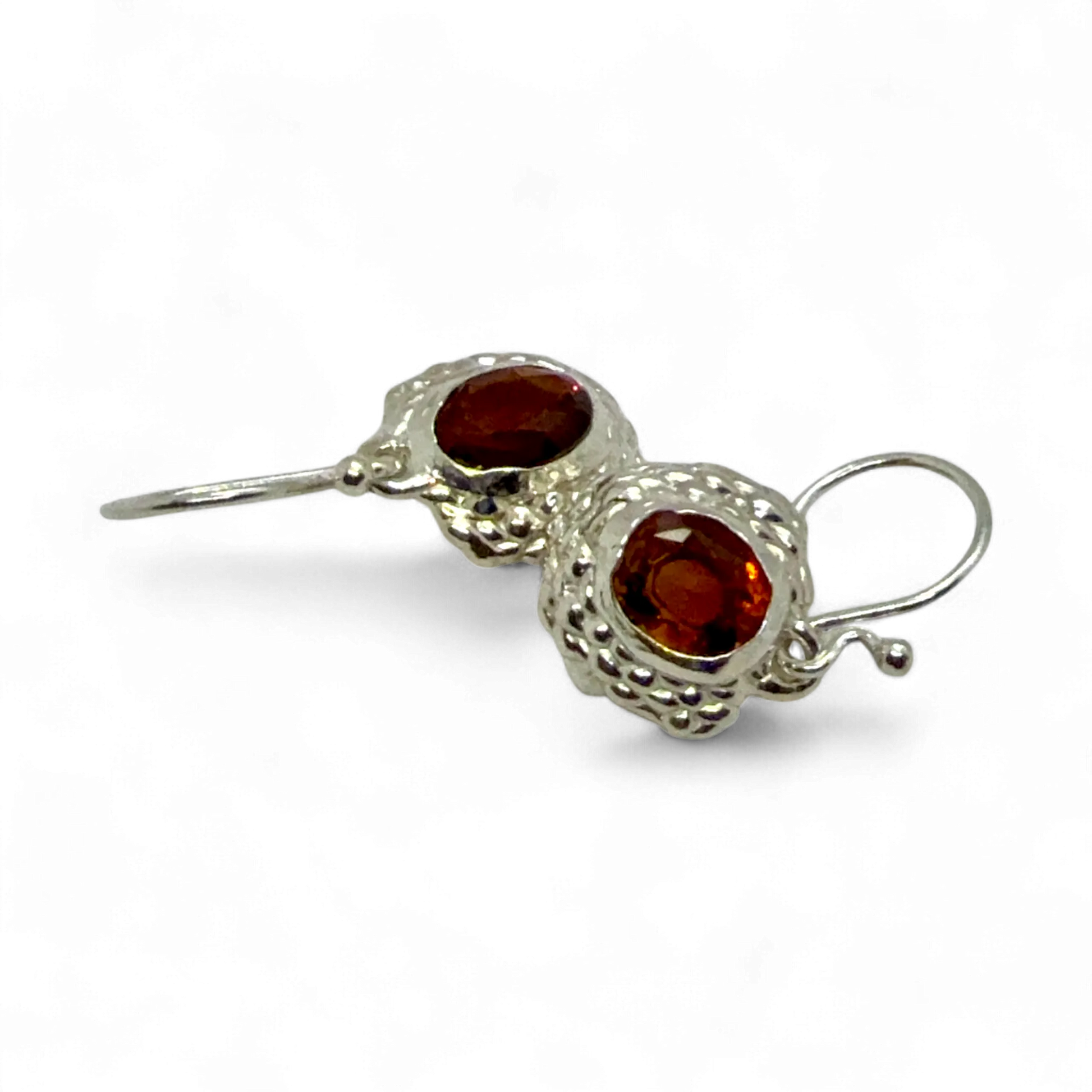 Close-up of Sola Dangles — sterling silver dangle earrings with faceted orange citrine gemstones.