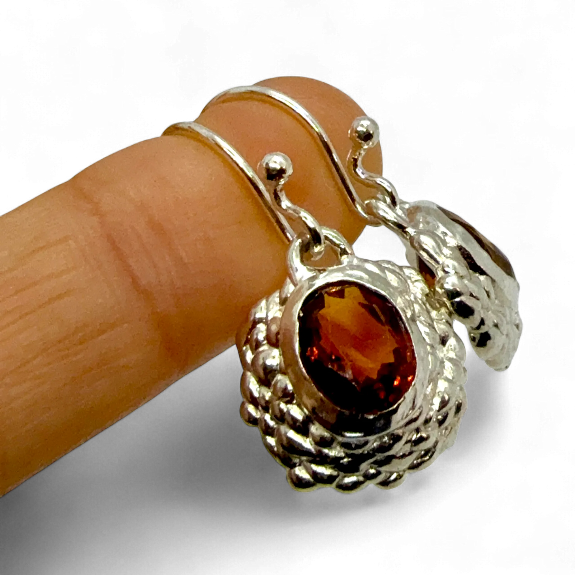Sola Dangles worn on finger — handmade sterling silver and orange citrine earrings by Lia Makes Jewellery.