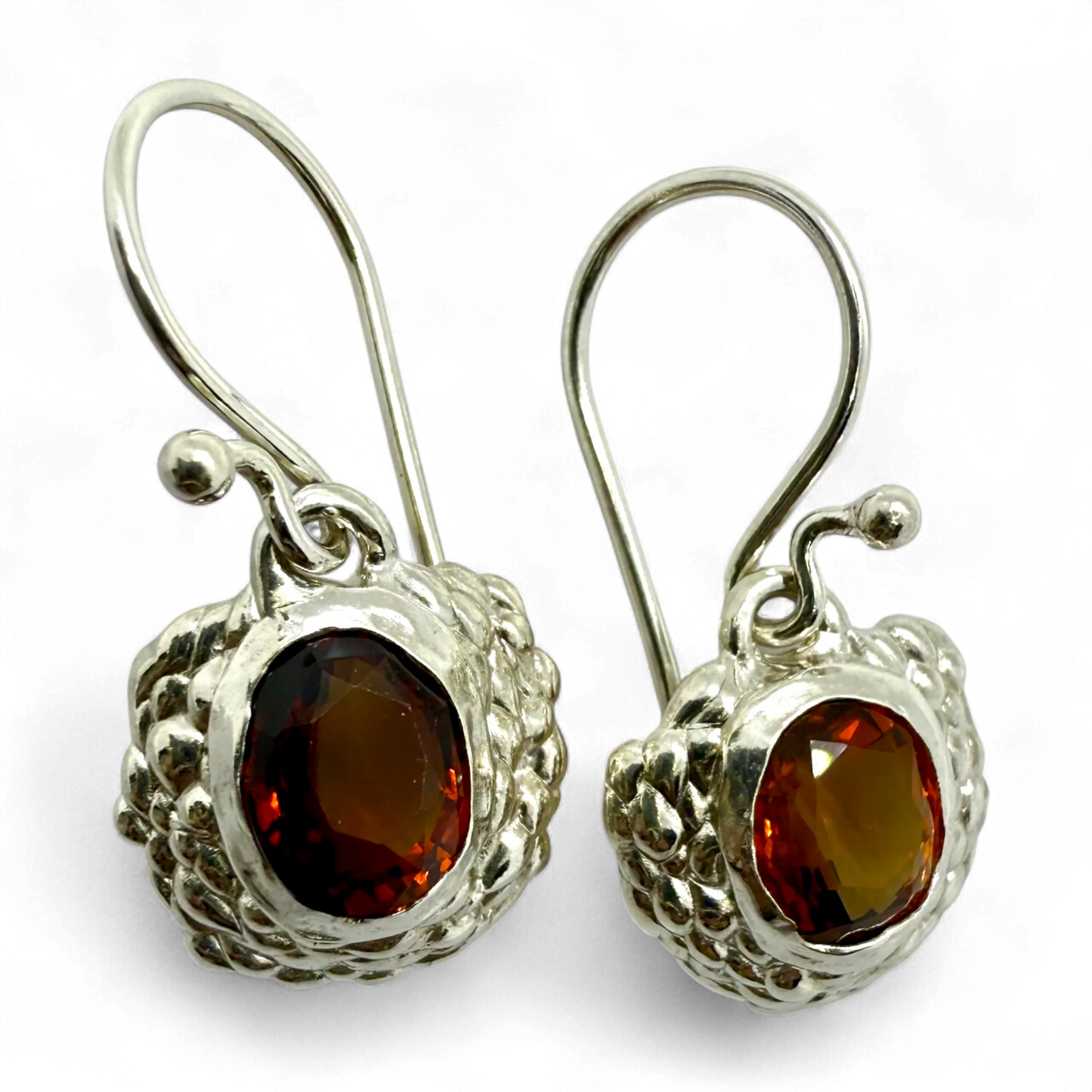 Side view of Sola Dangles showing polished silver and glowing orange citrine stones.