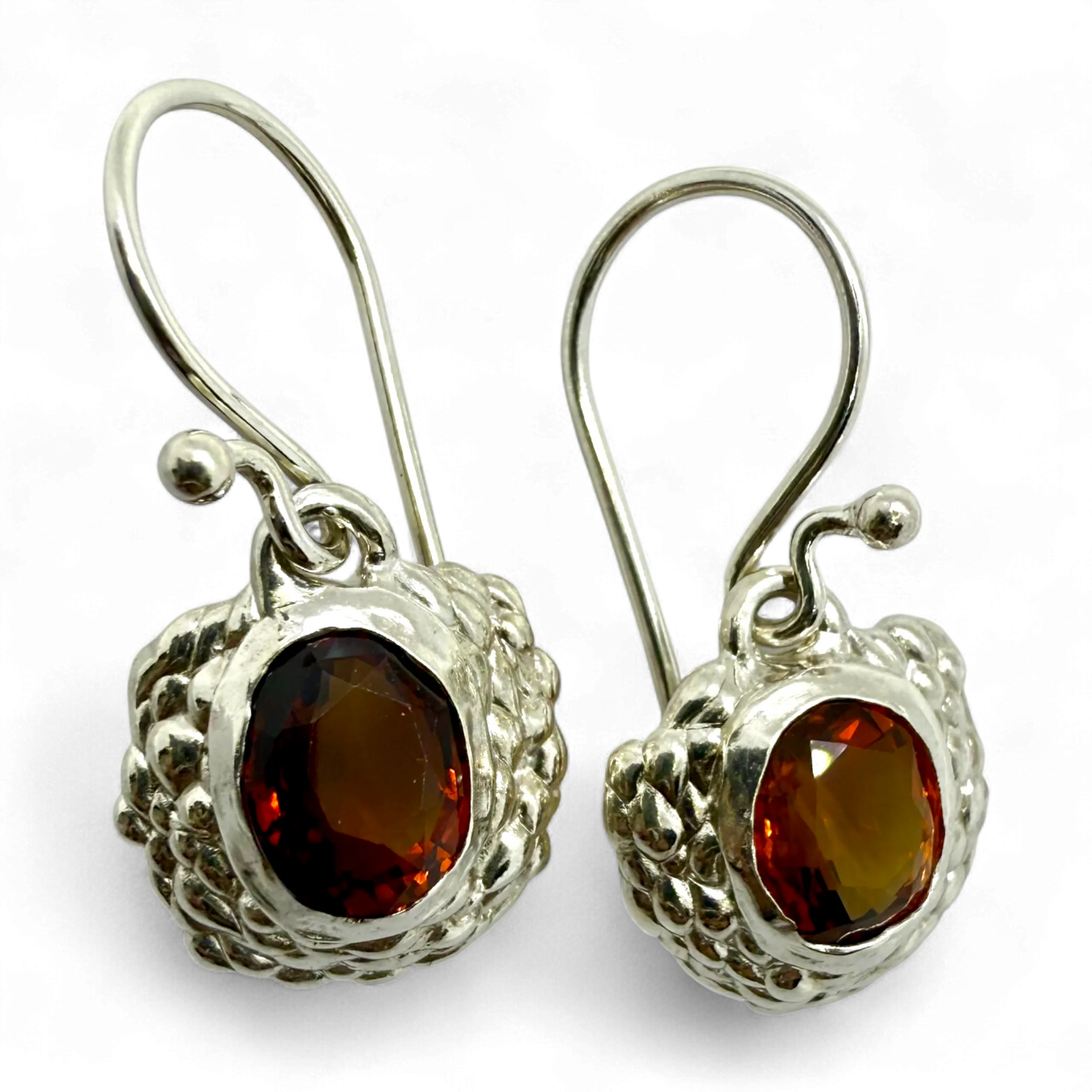 Side view of Sola Dangles showing polished silver and glowing orange citrine stones.