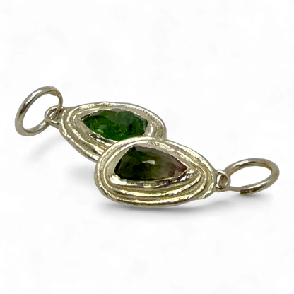 Close-up of Orra Hoops — handmade silver hoop earrings featuring soft pink and green tourmalines.