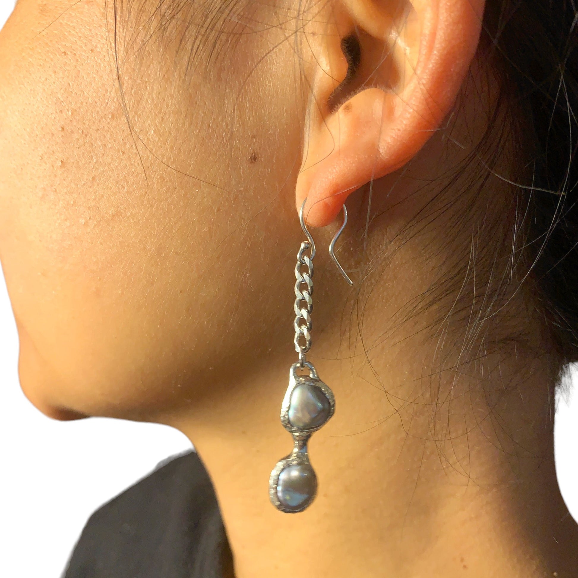 Add a touch of elegance to your daily style with these stunning grey pearl dangles. Handmade from sterling silver and featuring a beautiful grey pearl hanging from a curb chain, they're the ultimate casual-chic dangles. 