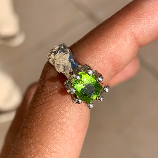 Jungle Queen ring is handmade from sterling silver and features a beautiful green peridot stone securely held in place by silver claws to showcase its captivating colour. It is available in size K 1/2. 
