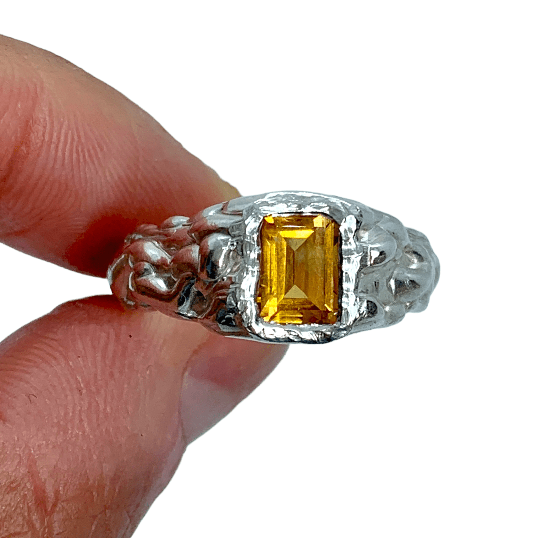 Kuning Ring in silver with yellow citrine and wavy band, holding against white background. Handmade by Lia in Paris.