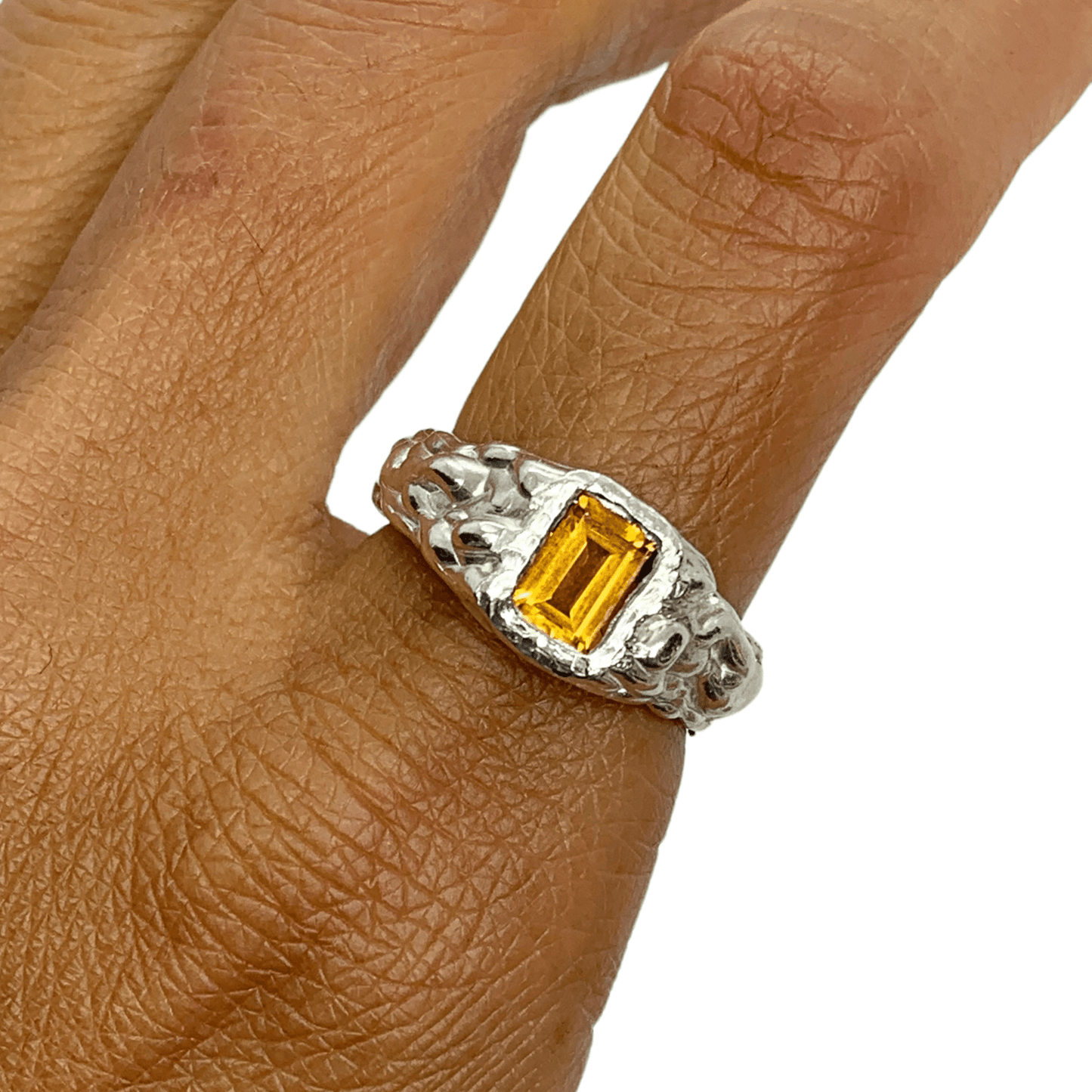 Kuning Ring in silver with yellow citrine and wavy band, shown on pointer finger against a white background. Handmade by Lia.
