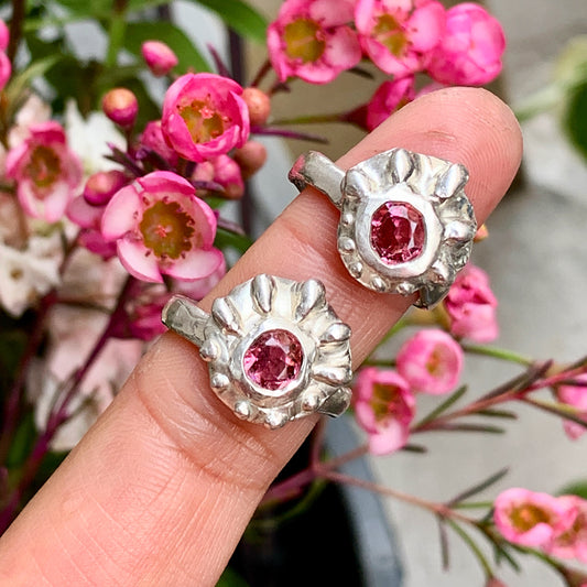 Introducing the Raffles Ring, a fun and casual silver ring that features a pretty pink spinel stone in the middle and a bumpy pattern around the stones that gives it a unique and playful look. It's perfect for everyday wear.
