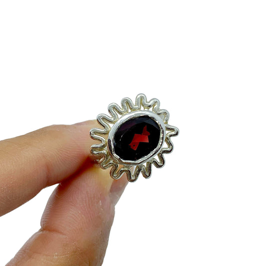 Sterling silver ring with red garnet and open-back design, fits sizes L–N in white background. Handmade by Lia in Paris