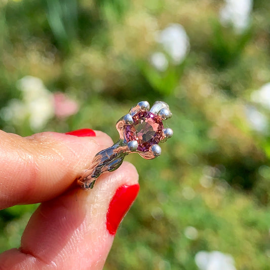 The Rosette ring coms with pink spinel stone. Made with sterling silver and held securely in place by six claws, this ring comes in a size K 1/2 or 5 3/8.
