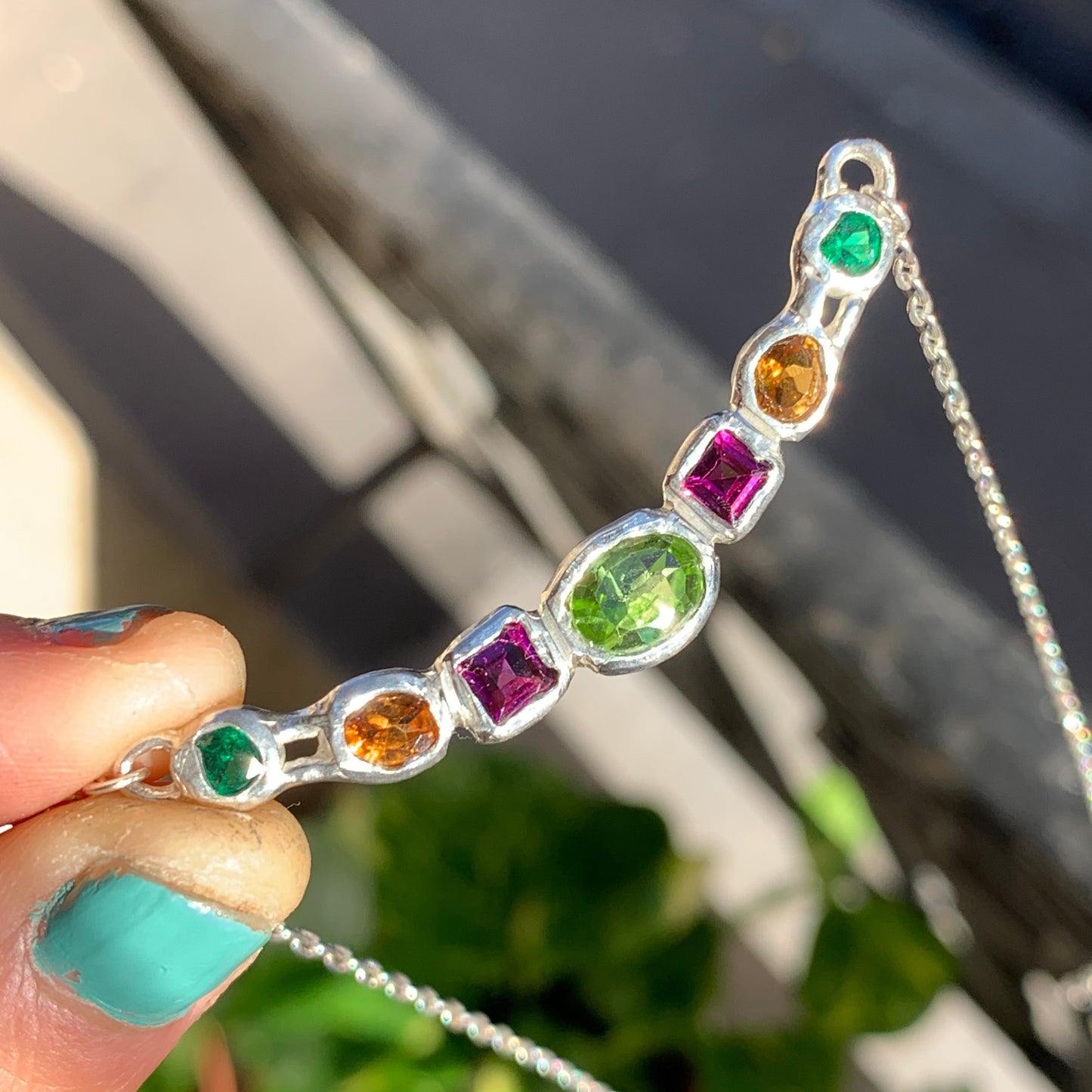 Sterling silver Warna-Warni Necklace with colourful stones, 42 cm long with balcony as background. Handmade by Lia in Paris.